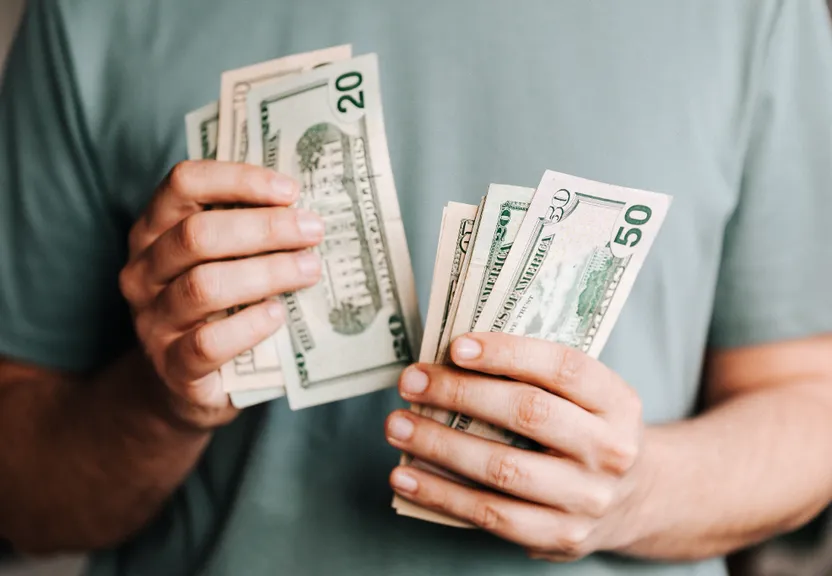 a man holding a stack of cash in his hands