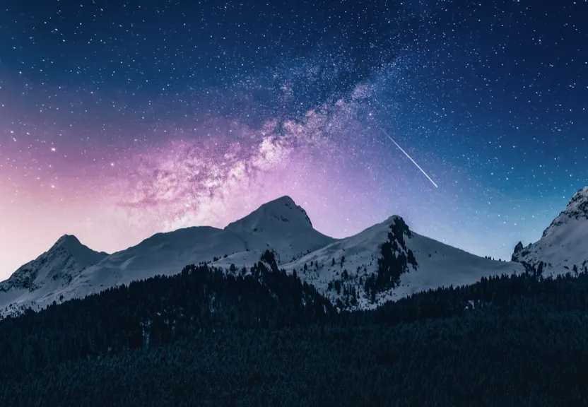 a night sky filled with stars above a mountain range