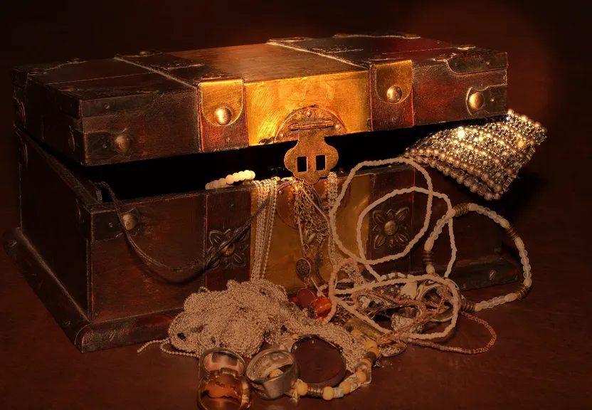 an old trunk with a chain, bells, and other items