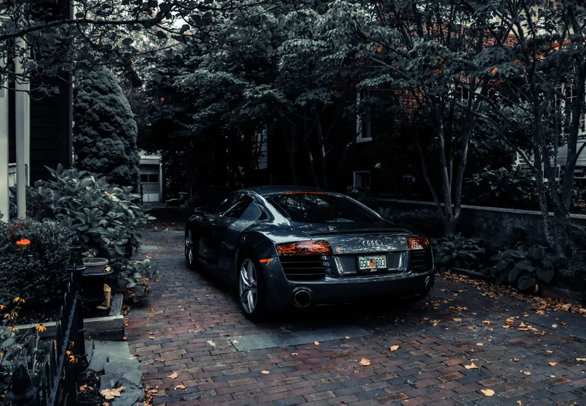 a black sports car parked in front of a house