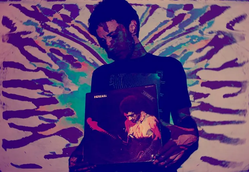 a man holding a laptop in front of a painting