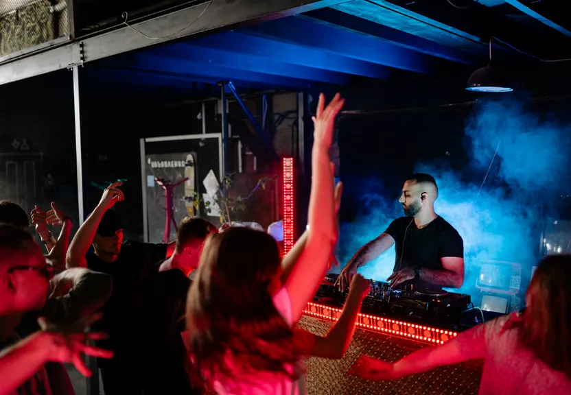 a group of people that are standing in front of a dj