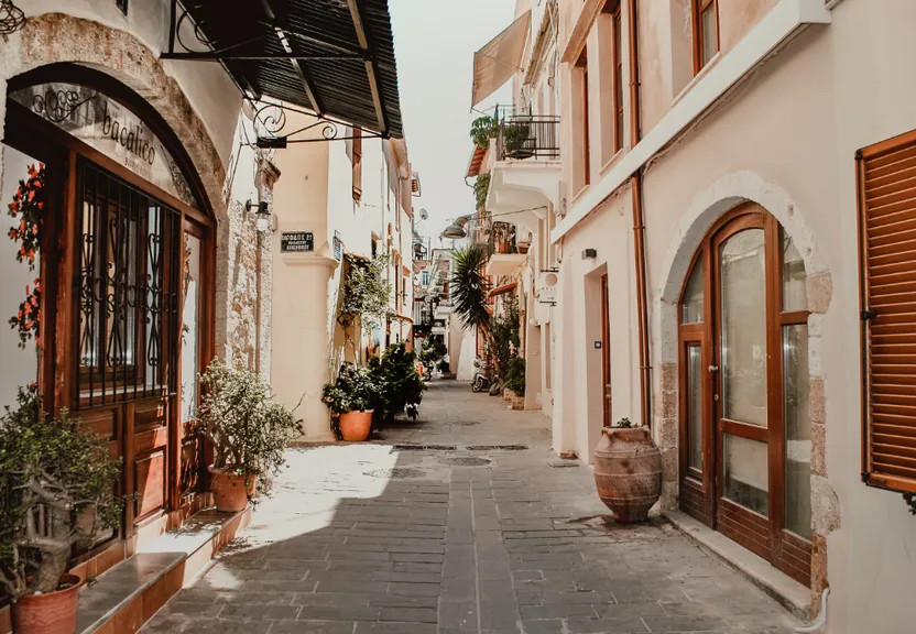 a narrow street with potted plants on either side