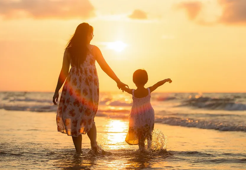 a woman and a child are standing in the water at the beach