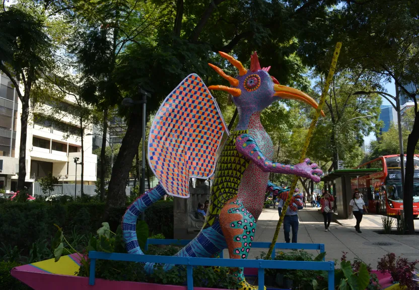 a statue of a dragon holding a kite in a park