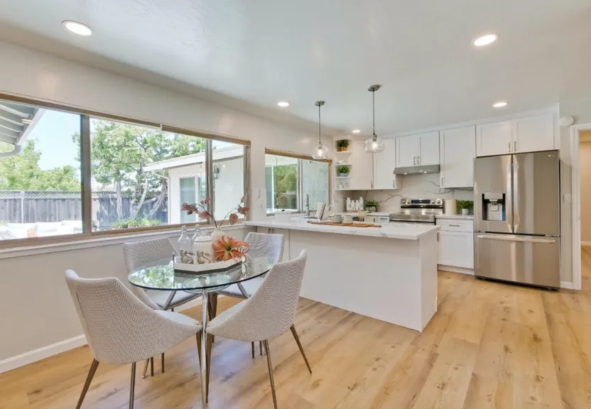 a kitchen with a glass table and white chairs