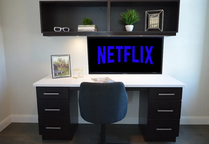 a desk with a chair and a television on it