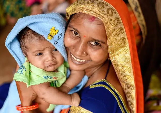 a woman holding a baby in her arms