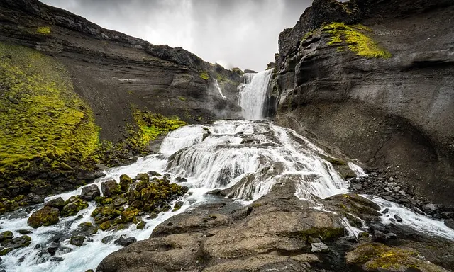 a waterfall with moss growing on the rocks