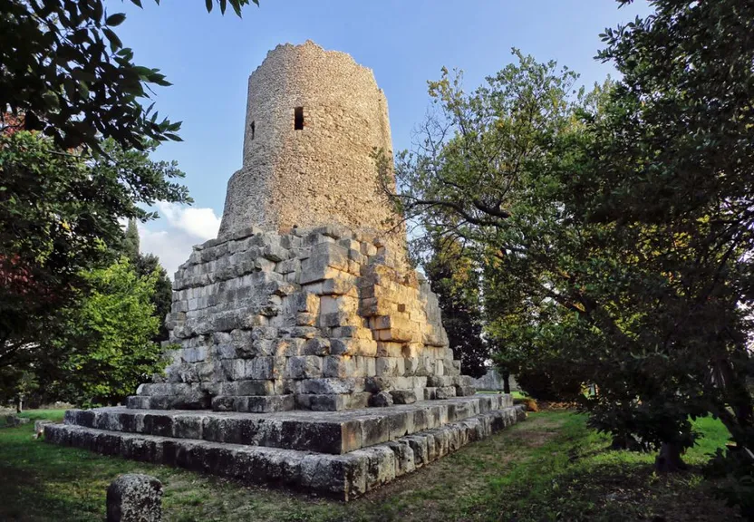 a stone tower sitting in the middle of a park