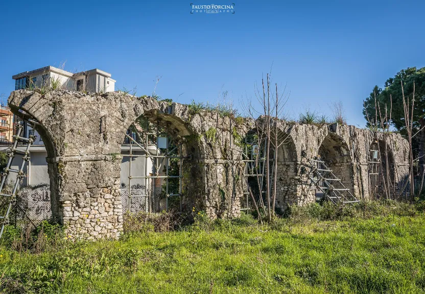 an old stone building with vines growing out of it