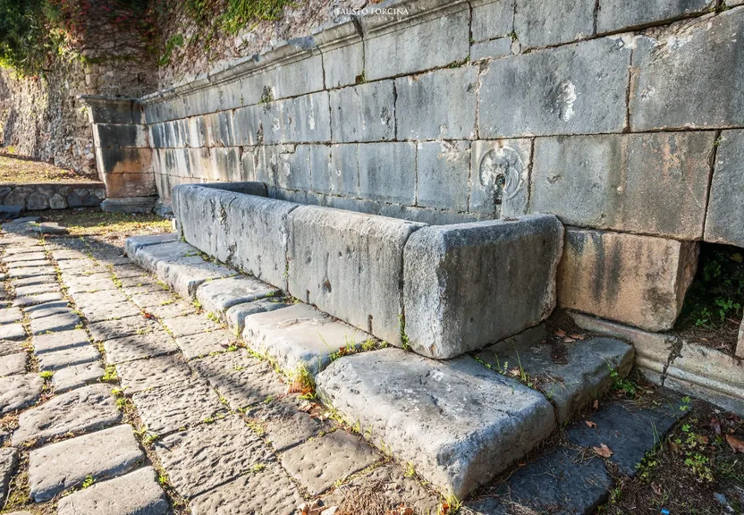 a stone bench sitting next to a stone wall