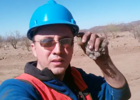 a man wearing a blue hard hat and sunglasses