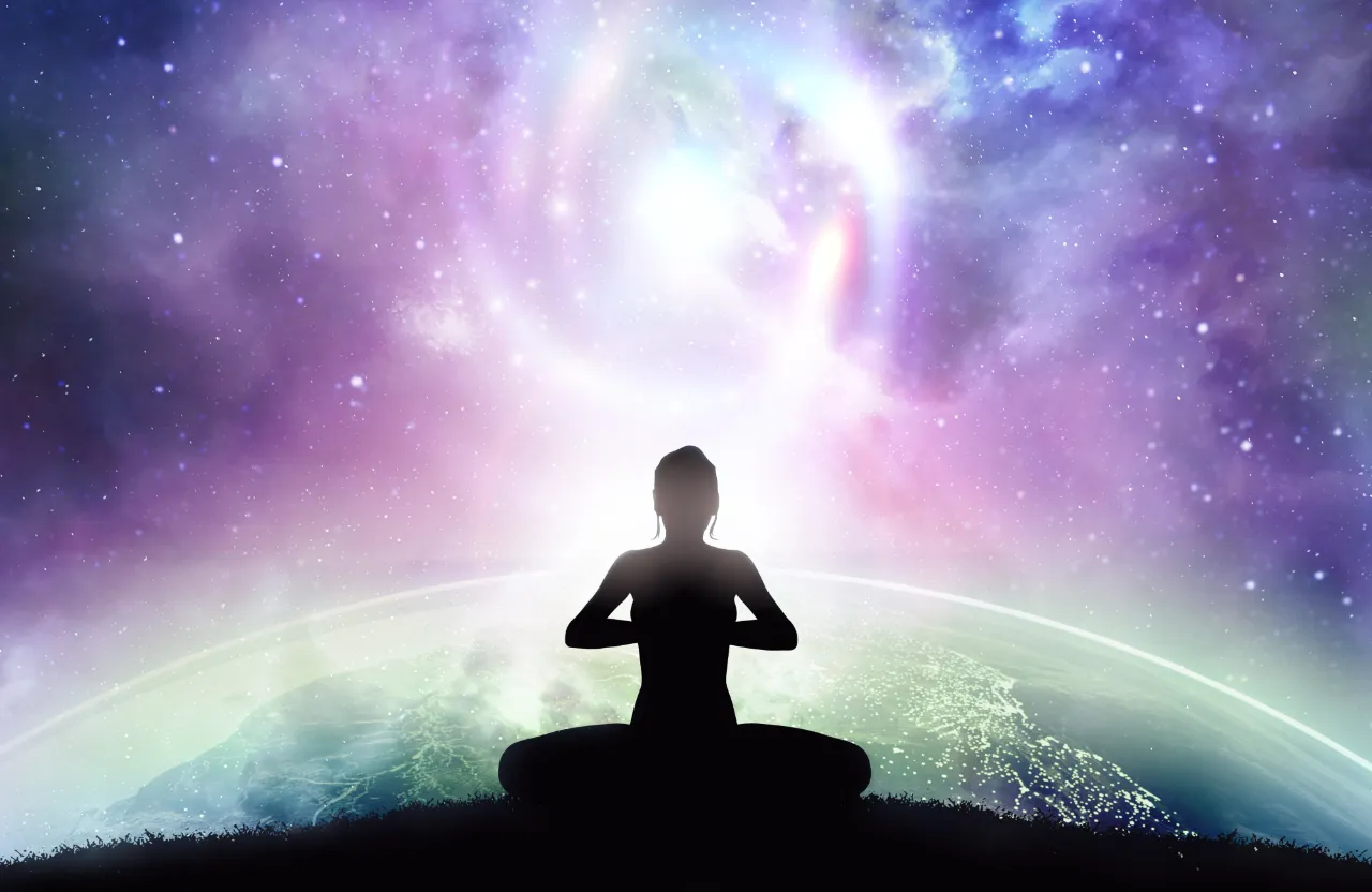 a person sitting in a yoga position in front of a galaxy background