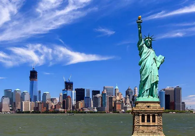 the statue of liberty stands in front of the new york city skyline