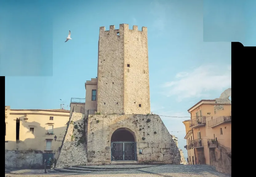 a tall tower with a door in the middle of a street