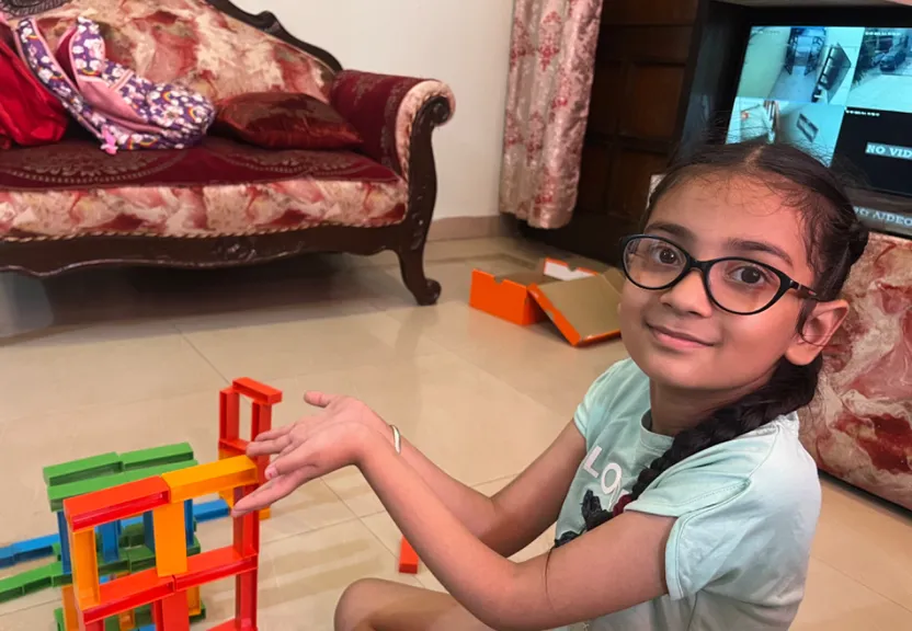 a young girl playing with blocks on the floor also add domino’s game