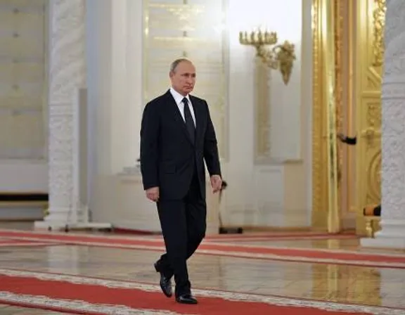 Putin  in a suit and tie walking in a room