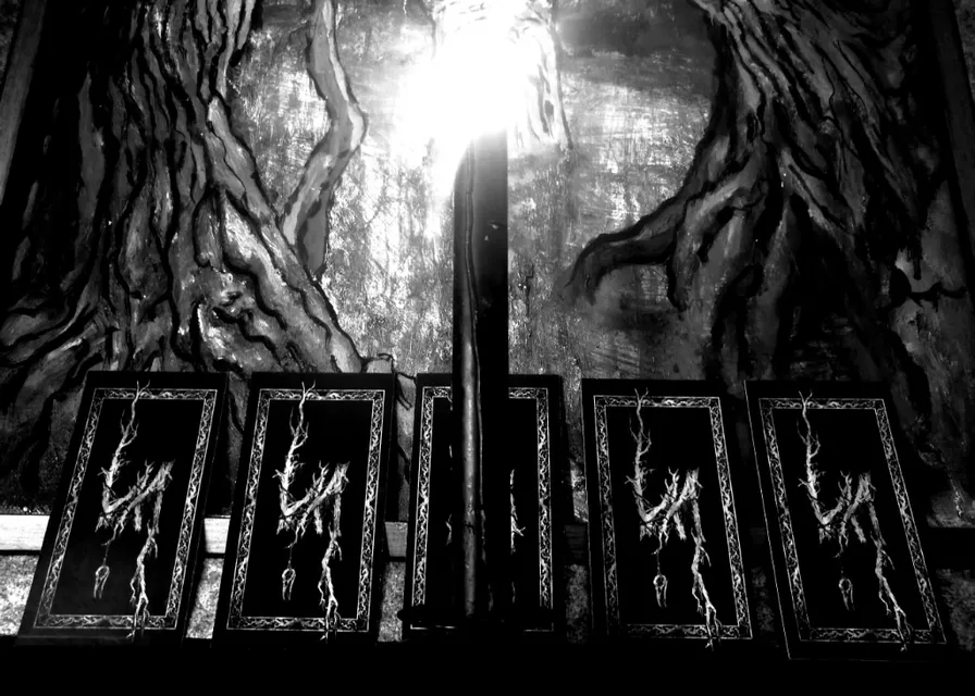 a black and white photo of a light shining through a window