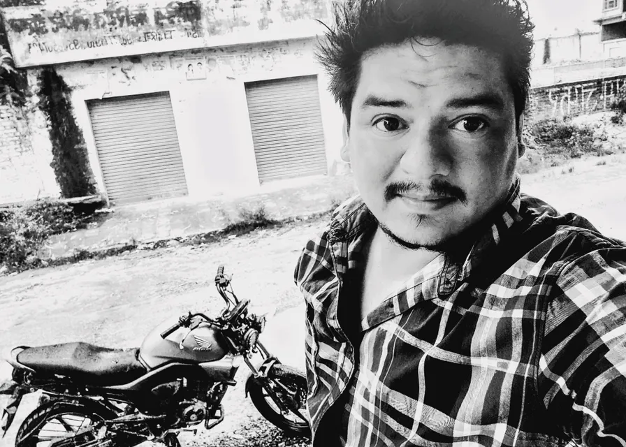 a black and white photo of a man with a moped