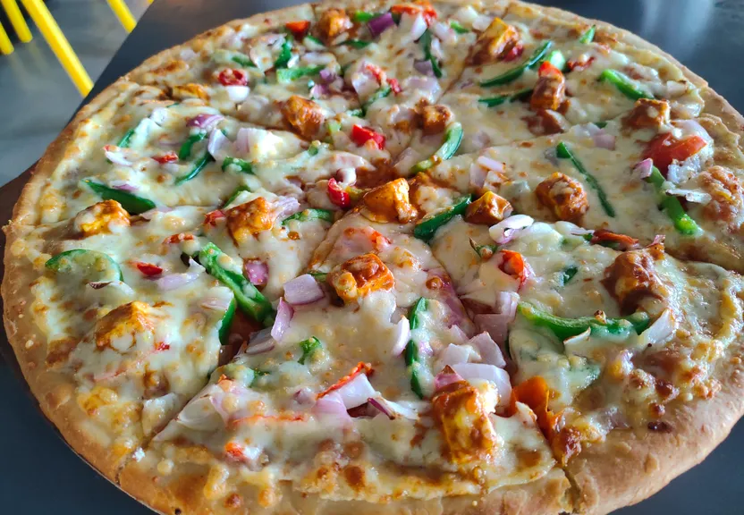 a pizza sitting on top of a pan covered in toppings