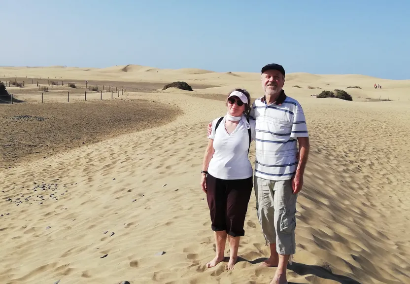a man and a woman standing in the sand