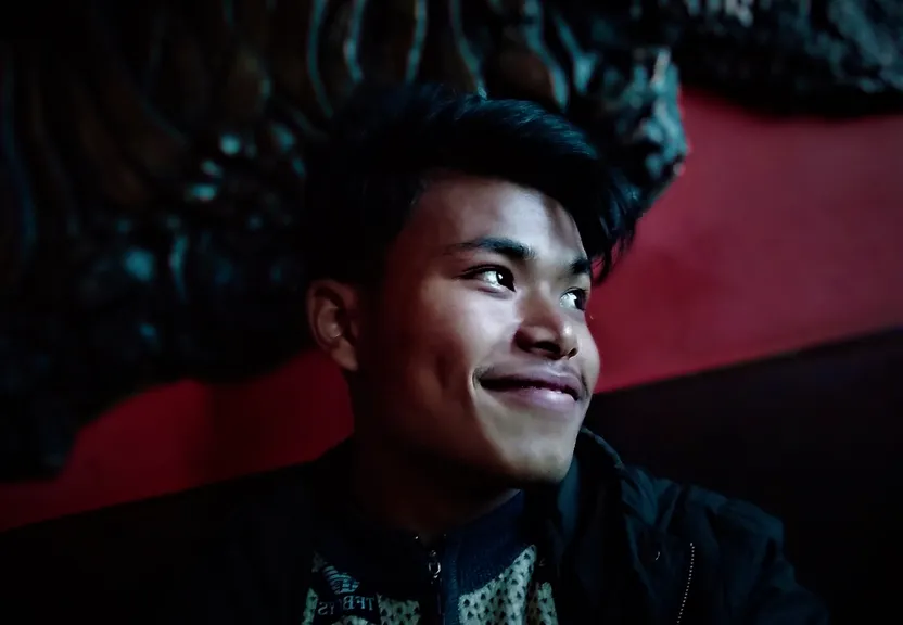 a young man is smiling in front of a dinosaur skeleton