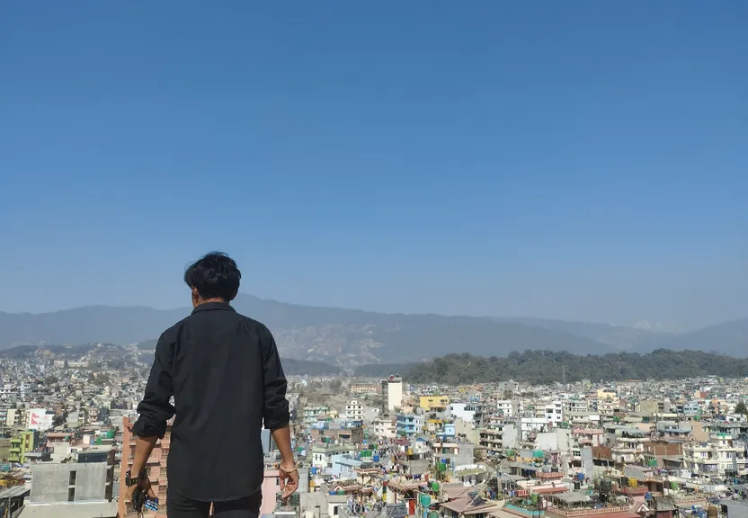 a man standing on top of a roof looking over a city