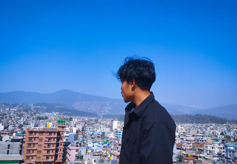 A man standing in front of a Field of Flowers. Make the cityscape a field of flowers