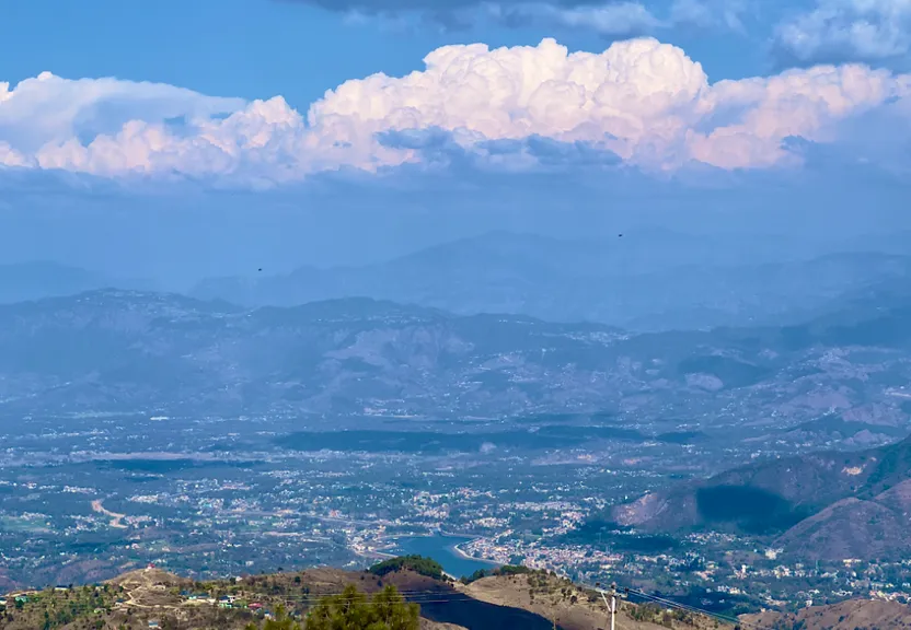 a view of a city and mountains from a hill