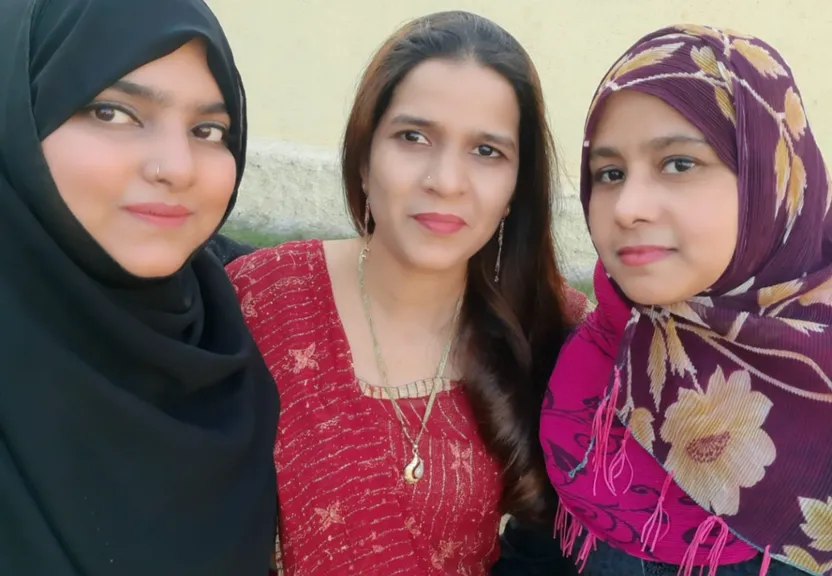 two women standing next to each other wearing headscarves