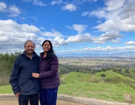 a man and a woman standing on top of a hill