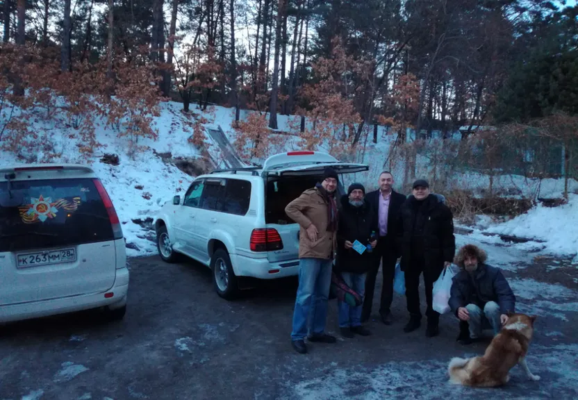 a group of people standing next to a white van