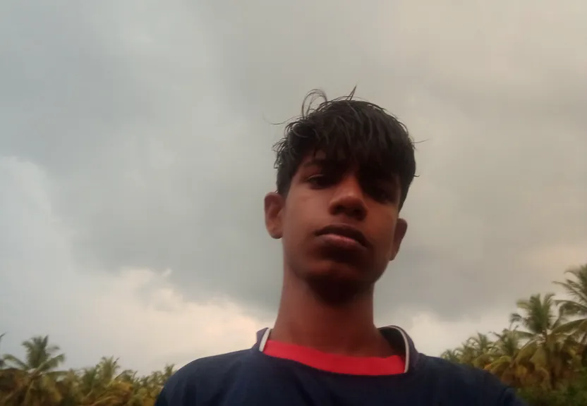 a young man standing in front of a cloudy sky