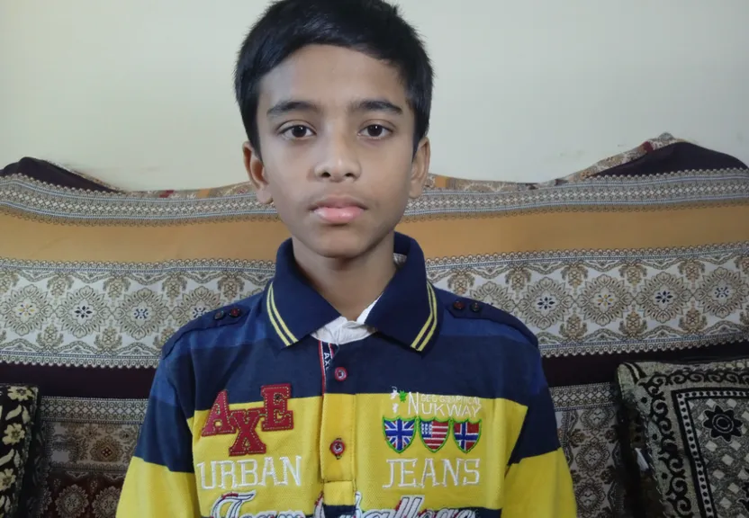 a young boy in a yellow and blue shirt