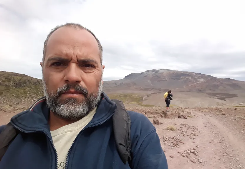 a man with a beard standing on a dirt road
