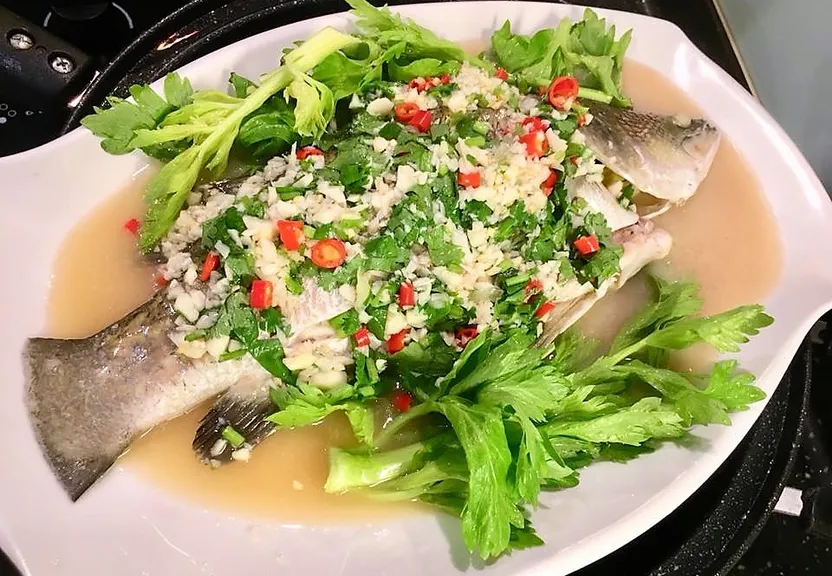 a white plate topped with fish covered in sauce