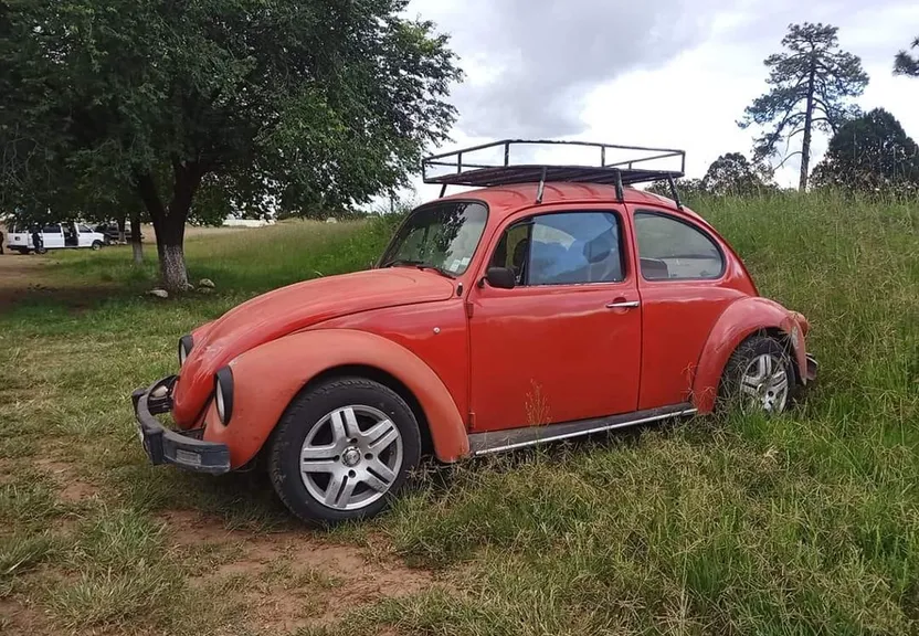 a red car parked in a grassy field