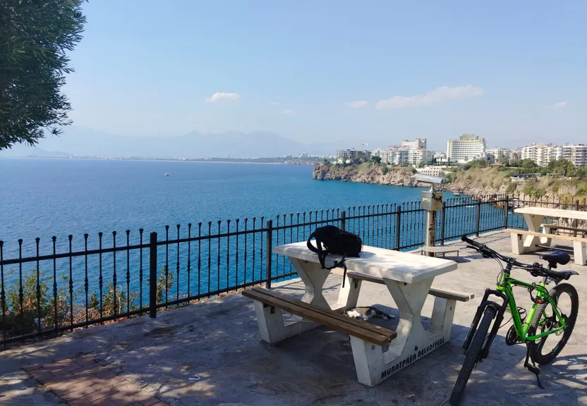 a bicycle parked next to a bench near the ocean