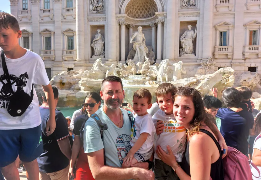 a group of people standing in front of a fountain