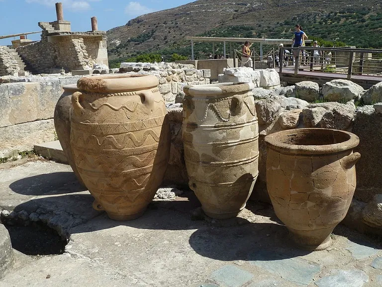 a couple of large vases sitting on top of a stone floor