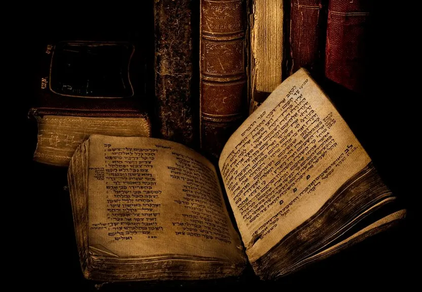 an open book sitting on top of a pile of books