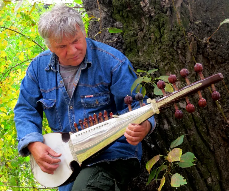 a man playing a musical instrument in the woods