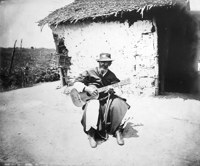 a black and white photo of a man playing a guitar