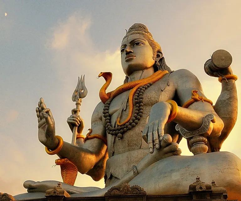 a statue of a hindu god holding a snake