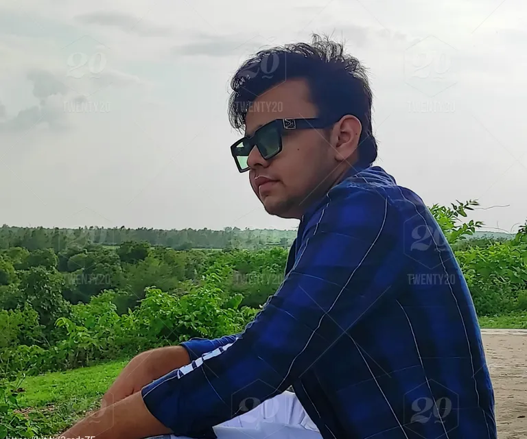 a man wearing sunglasses sitting on a bench