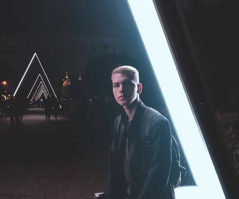 a man standing in front of a building at night