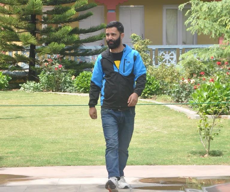 a man with a beard walking down a sidewalk