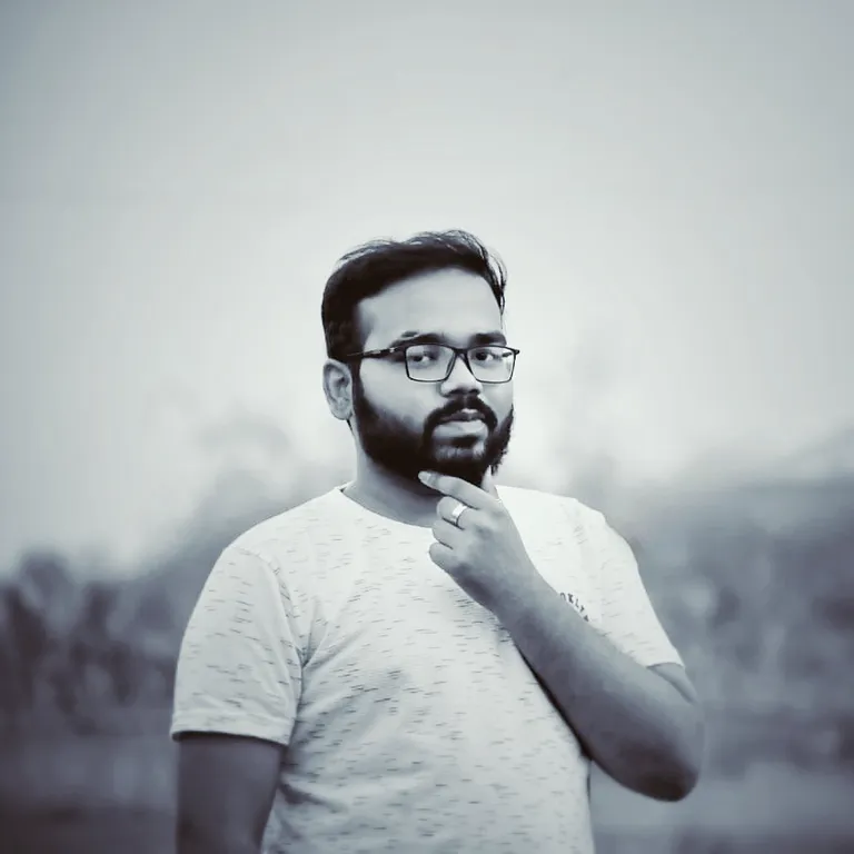 a man with a beard and glasses is brushing his teeth