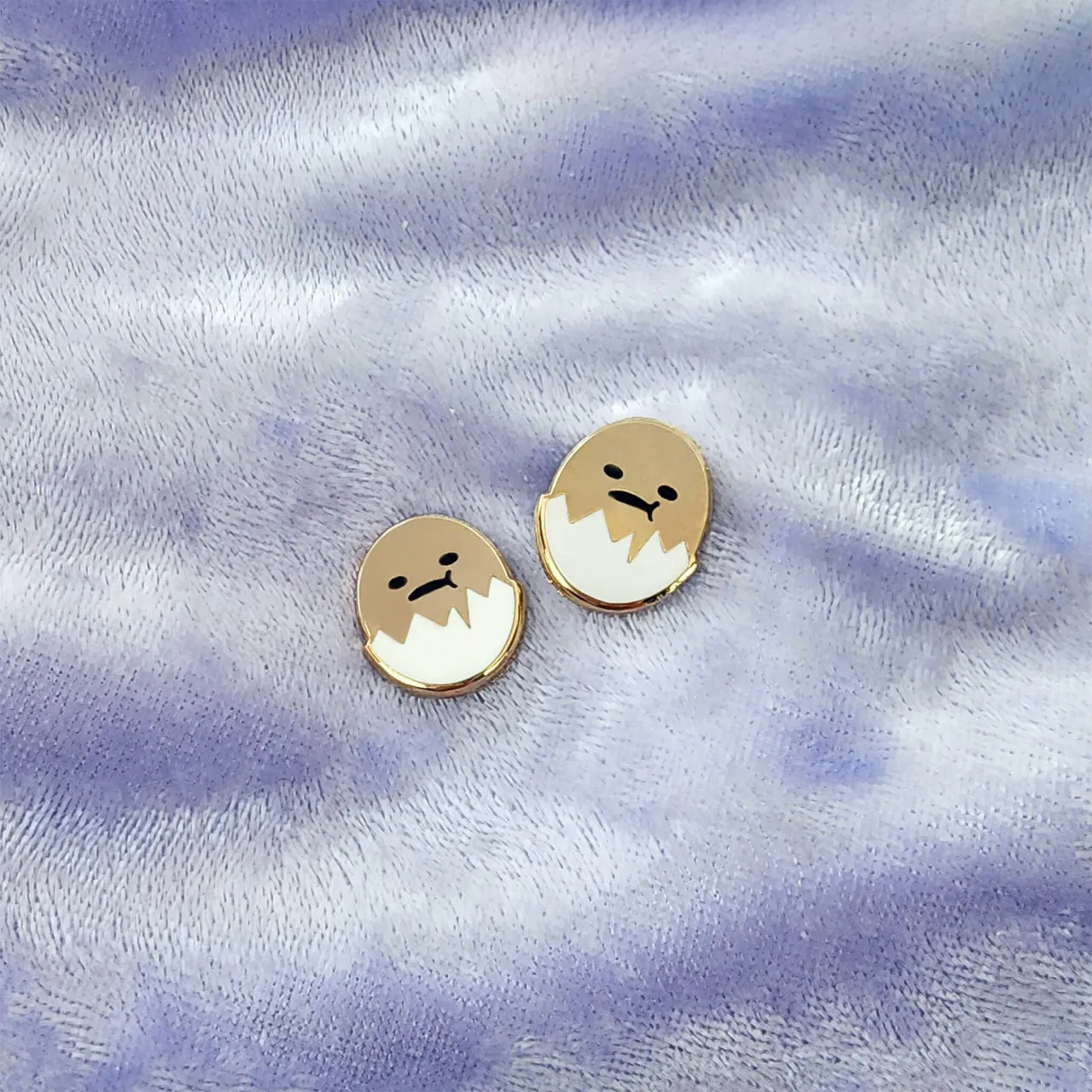 a pair of earrings with a face drawn on it